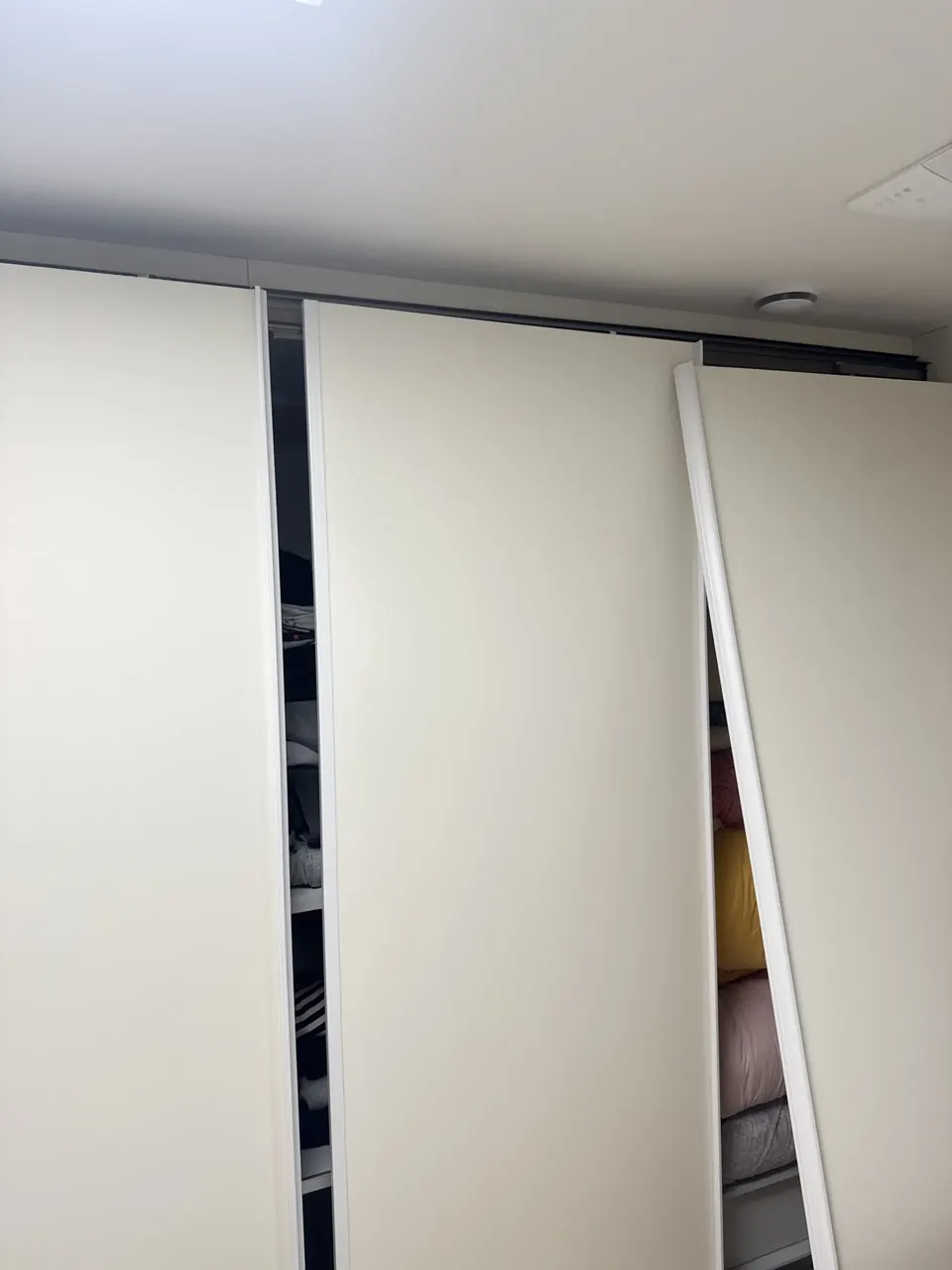 수리 전 가운데 문짝이 떨어져 기울어진 흰색 붙박이장